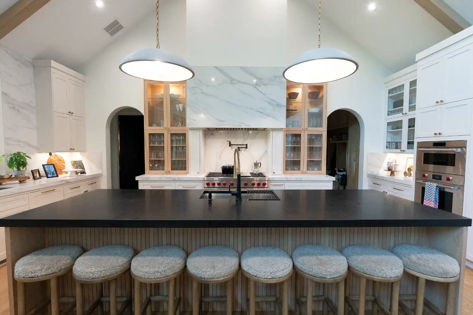 Full-height white shaker cabinetry running to a vaulted ceiling
