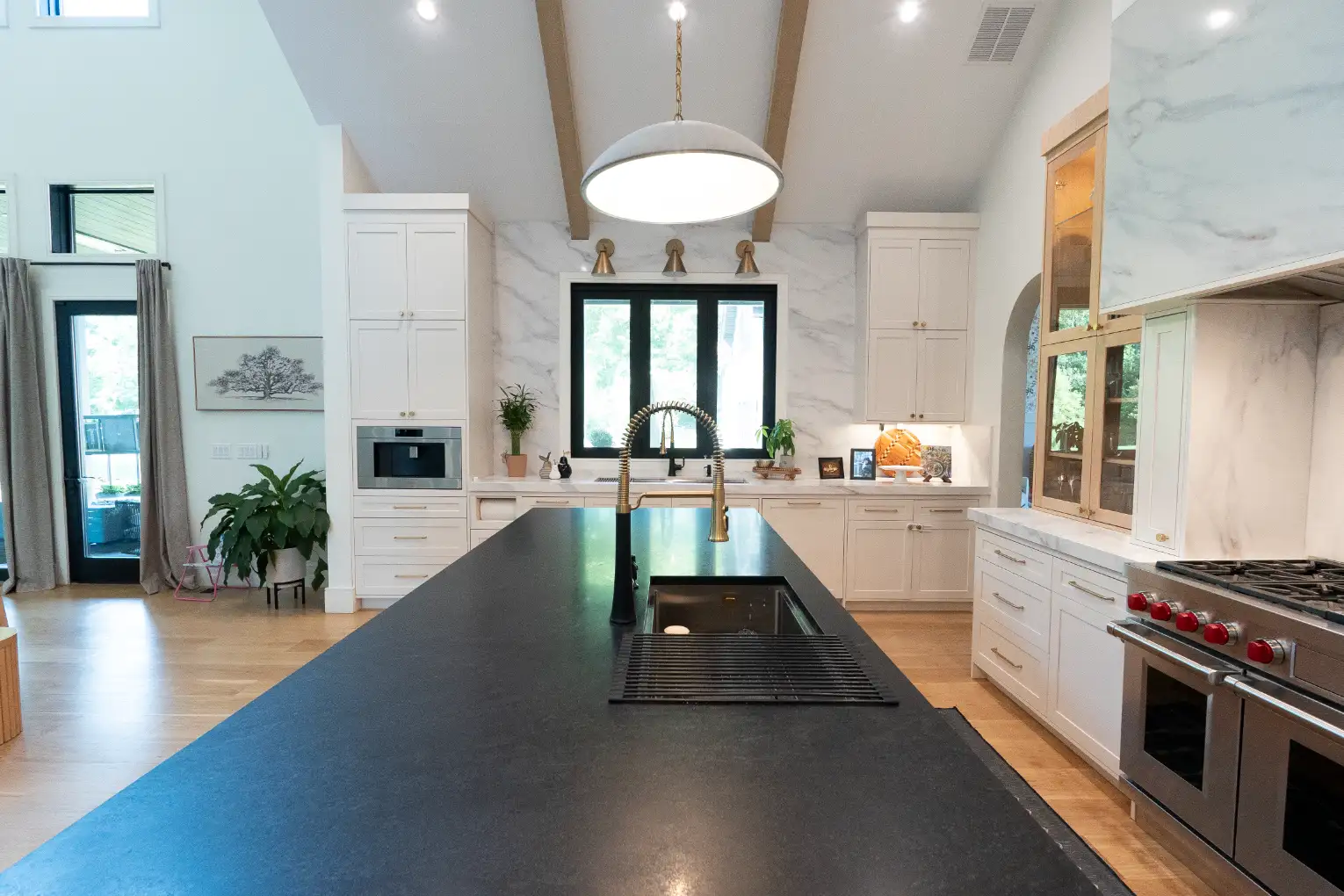 Custom integrated range hood above a quartz countertop and tiled splashback
